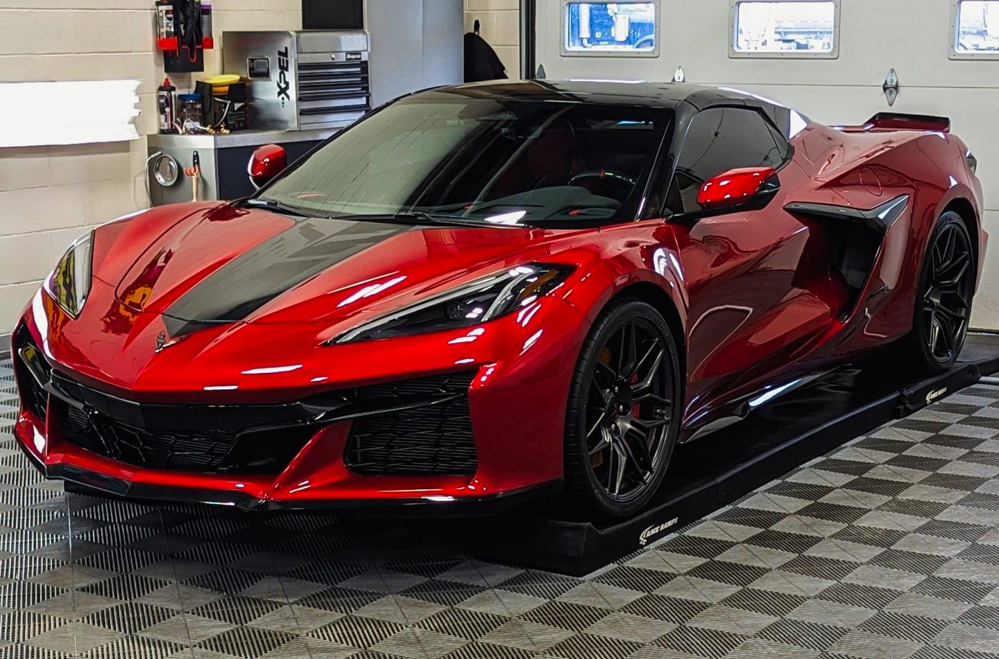 Red Corvette Z06 on ramps in the paint protection bay